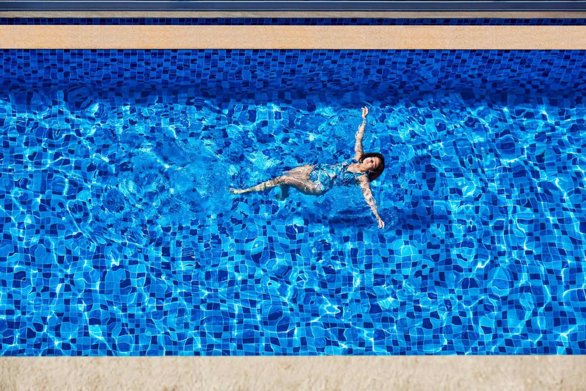 Novotel Mumbai International Airport Exterior foto A woman floating in a swimming pool